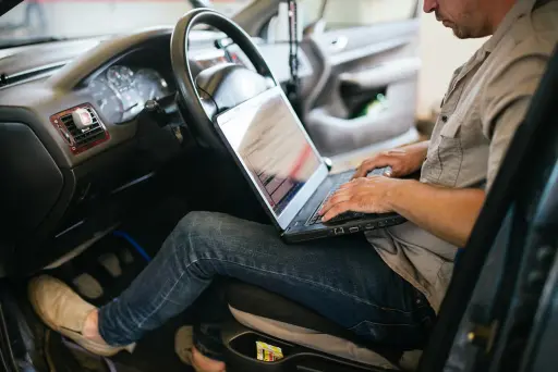 Mechaniker am OBD-Stecker mit Diagnosegerät Mechaniker am OBD-Stecker mit Diagnosegerät prüft DPF